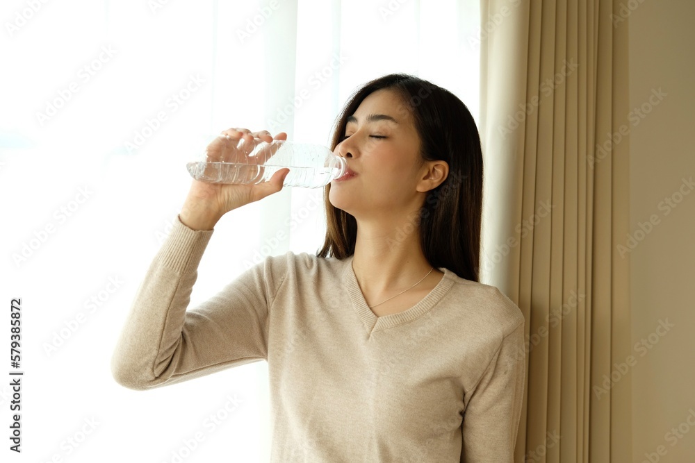 Morning of beautiful young woman drinking water in bedroom Morning of beautiful young woman drinking water in bedroom