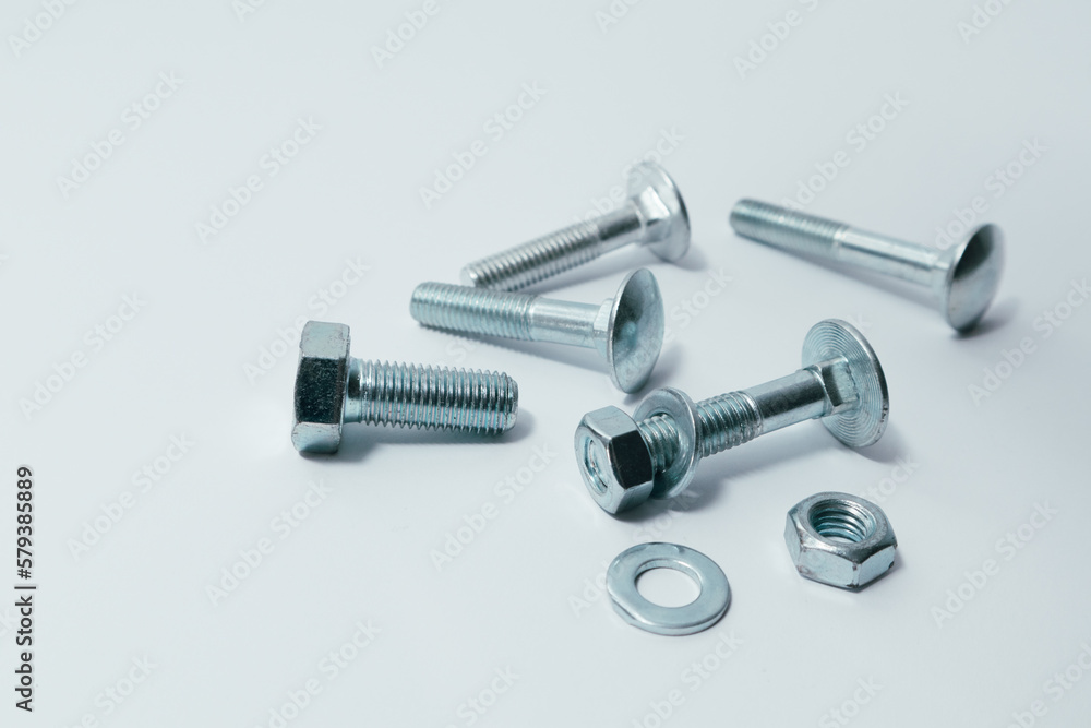 Close-up of various steel nuts and bolts. Mechanical, constructional still life. Nut and bolts on white background. Close-up of various steel nuts and bolts. Mechanical, constructional still life. Nut and bolts on white background.