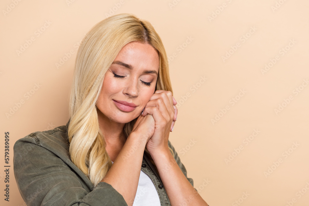 Fototapeta premium Photo of gentle pretty lovely lady wear khaki cozy clothes two arms touch cheeks near empty space isolated on beige color background