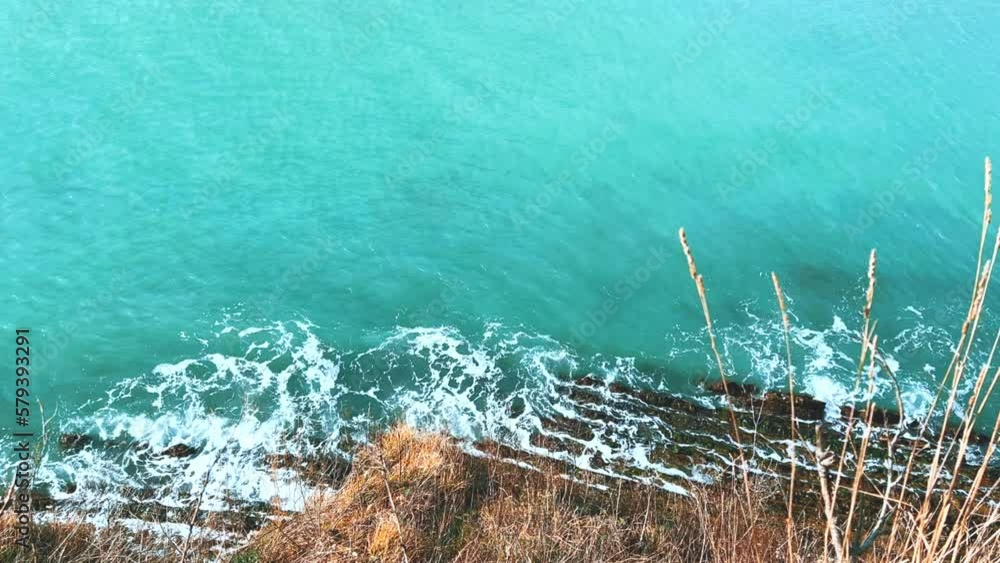 Panoramic view of the Black Sea coast from the mountain through the branches of trees. View of the blue water and the rocky seashore from the Kiselyov cliff. Sunset on the beach. 4K Panoramic view of the Black Sea coast from the mountain through the branches of trees. View of the blue water and the rocky seashore from the Kiselyov cliff. Sunset on the beach. 4K