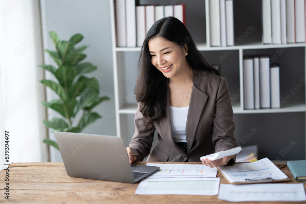 Beautiful businesswoman calculating and checking balance while sitting in the office room. Beautiful businesswoman calculating and checking balance while sitting in the office room.