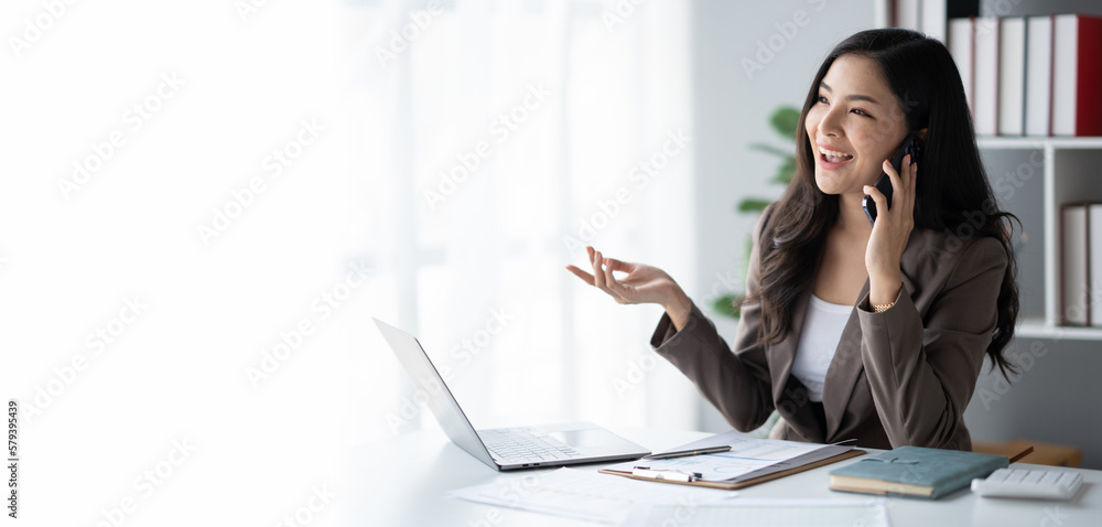Portrait of young Asian businesswoman having a phone call with her client in office room. Portrait of young Asian businesswoman having a phone call with her client in office room.