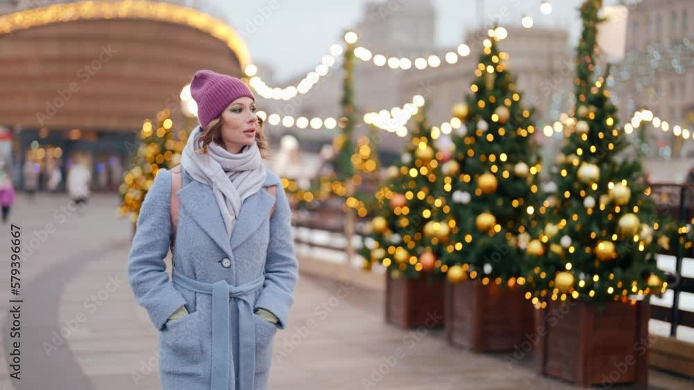 attractive middle-aged woman walking on city street in Christmas vacation, medium portrait outdoors attractive middle-aged woman walking on city street in Christmas vacation, medium portrait outdoors