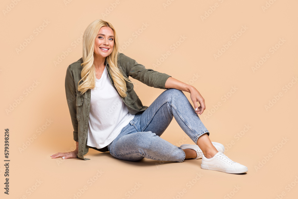 Full length photo of lovely cheerful lady wear comfort smart casual style clothes empty space isolated on beige color background Full length photo of lovely cheerful lady wear comfort smart casual style clothes empty space isolated on beige color background