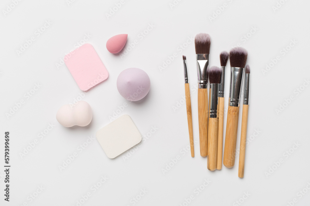 Make up brush and sponge on color background, top view Make up brush and sponge on color background, top view