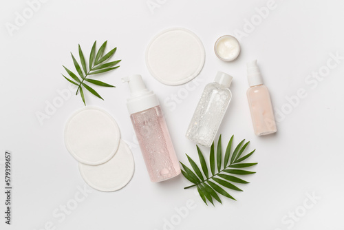 Face care products with eco pads on color background, top view