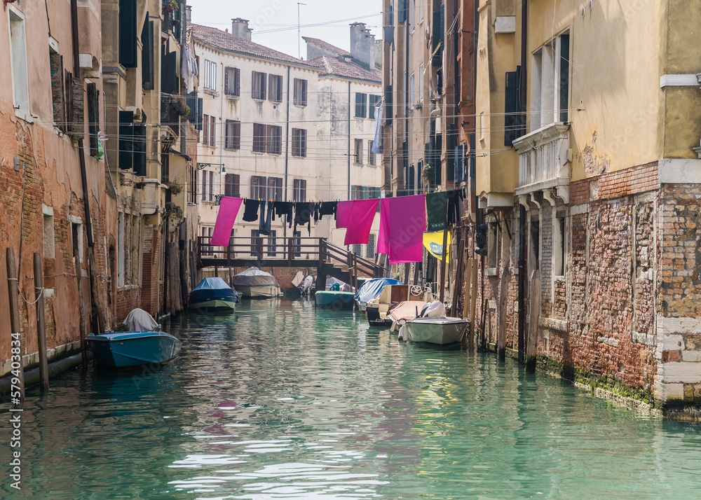 classic Venetian buildings by a canal and clothes hung to dry in Venice, Italy