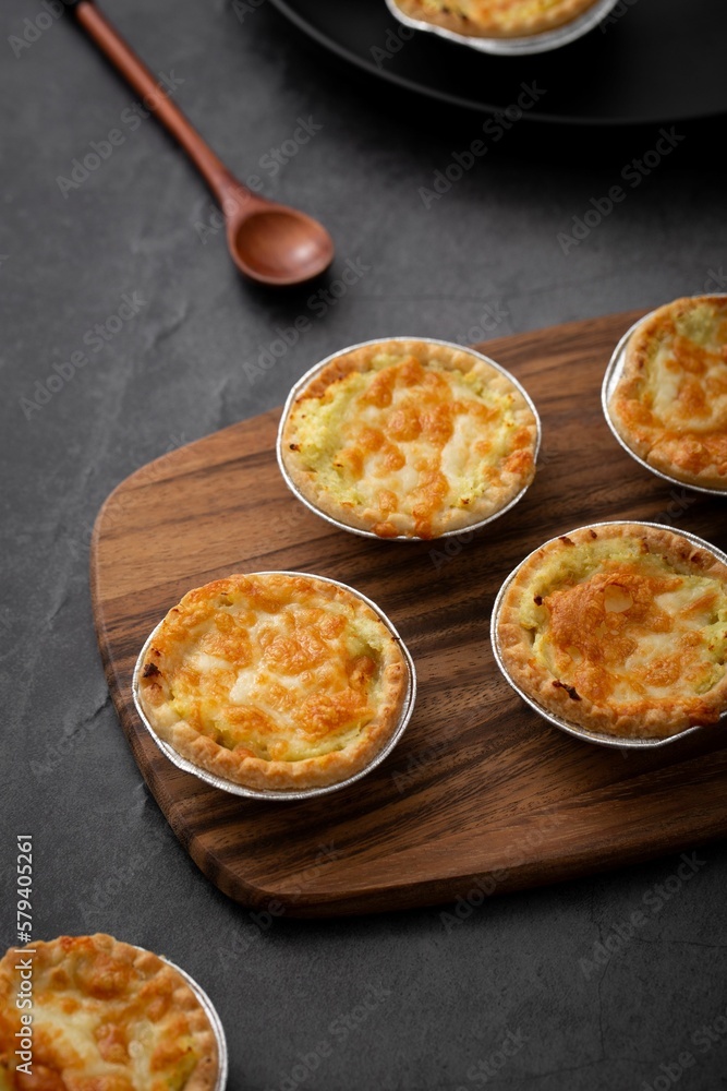 Vertical closeup of little pot pies served on a wooden tray Vertical closeup of little pot pies served on a wooden tray