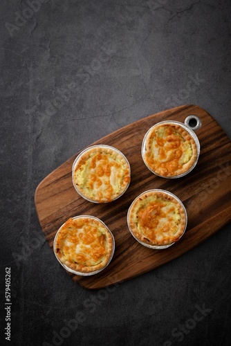Vertical top view of little pot pies served on a wooden tray