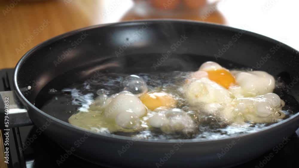 frying egg in a black pan frying egg in a black pan