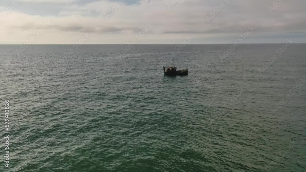 Drone video of old boat and fisherman fishing in sea Drone video of old boat and fisherman fishing in sea
