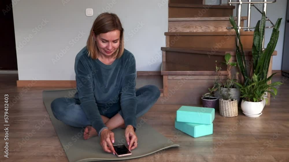 a woman does sports or yoga online on the phone. High quality FullHD footage a woman does sports or yoga online on the phone. High quality FullHD footage