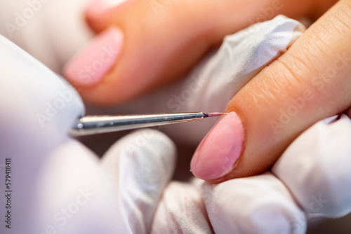 A large close-up of a woman's pink-painted nails