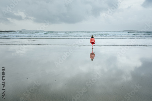 7 year old Girl Looking At The Sea On a Cloudy Day At The Beach photo