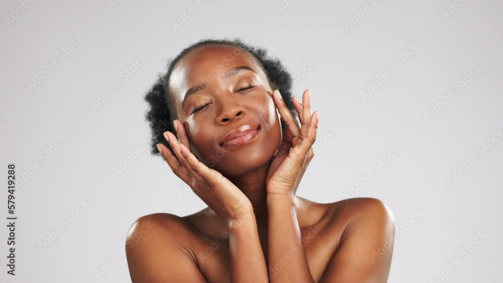 Glow, portrait and black woman feeling her face isolated on grey studio background. Cosmetic, smile and African girl touching facial skin for a soft, feminine and clear complexion and mockup Glow, portrait and black woman feeling her face isolated on grey studio background. Cosmetic, smile and African girl touching facial skin for a soft, feminine and clear complexion and mockup