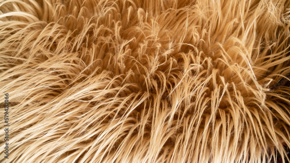 Long-haired plush fabrics. Close-up of light brown plush. Selective focus. Long-haired plush fabrics. Close-up of light brown plush. Selective focus.