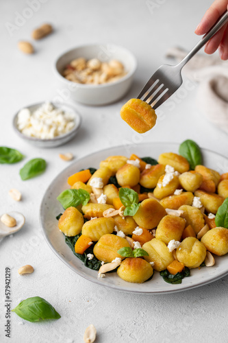 Fried Italian potato gnocchi with cheese and herbs on a white background. Italian food