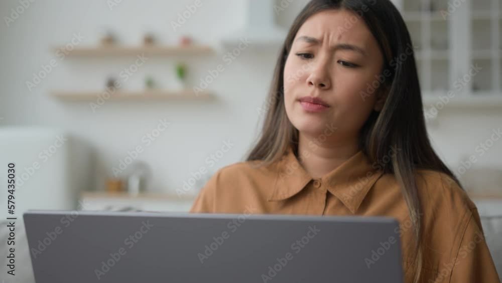 Angry upset Asian japanese woman girl homeowner using laptop in kitchen has problem stressed about mistake software error bug virus worried businesswoman work from home reading bad news fail business Angry upset Asian japanese woman girl homeowner using laptop in kitchen has problem stressed about mistake software error bug virus worried businesswoman work from home reading bad news fail business
