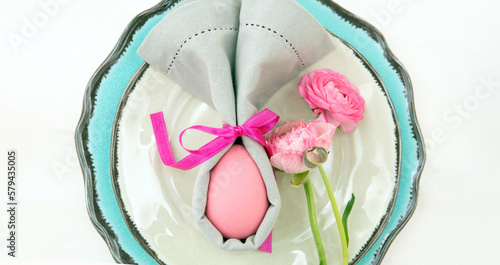 Easter table setting and decoration  Easter egg in a gray napkin on plates