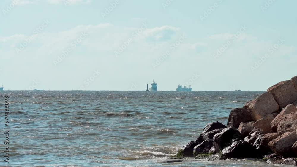 Slow motion of the calm waves of the Mediterranean Sea with ships in the background in Alexandria Slow motion of the calm waves of the Mediterranean Sea with ships in the background in Alexandria