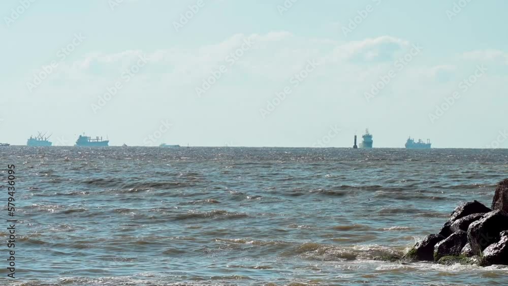 Slow motion of the calm waves of the Mediterranean Sea with ships in the background in Alexandria Slow motion of the calm waves of the Mediterranean Sea with ships in the background in Alexandria