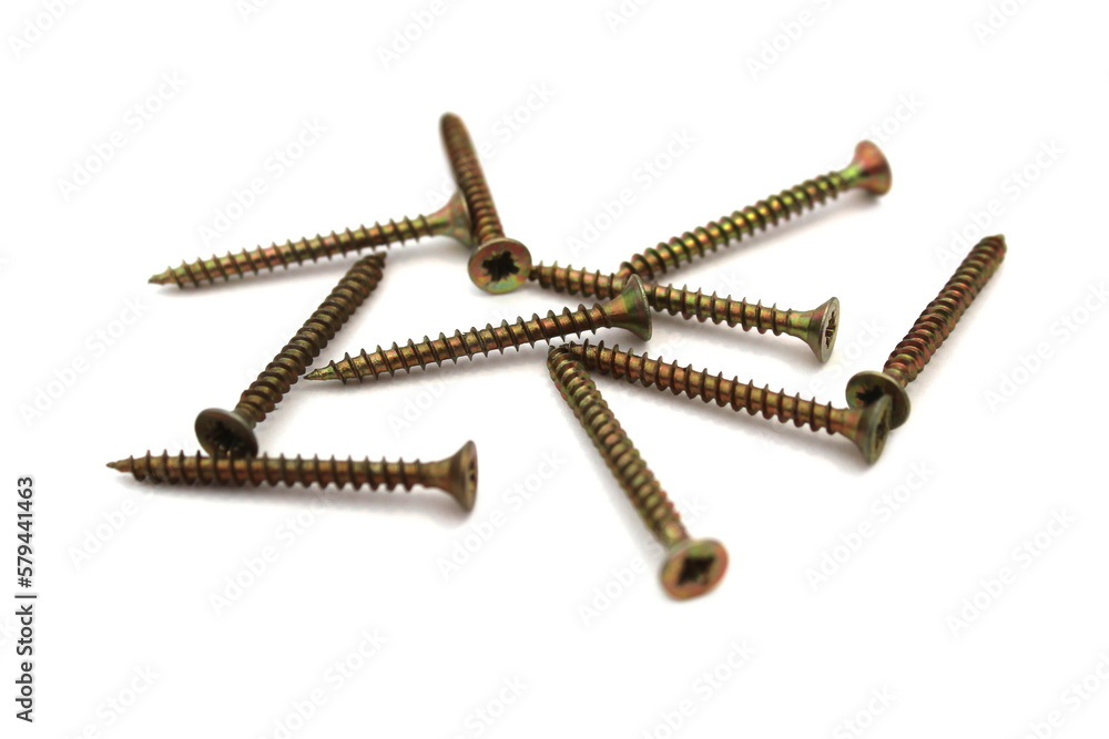 A lot of self-tapping screws lie on a white isolated background. A lot of self-tapping screws lie on a white isolated background.