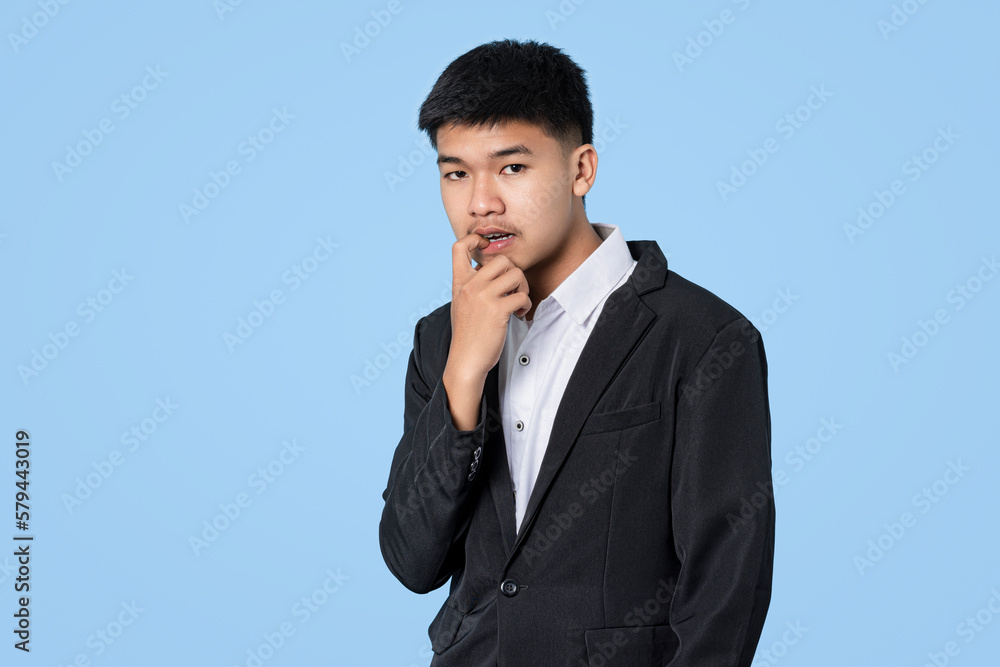 Young handsome asian businessman in panic, worry and scared face isolated on blue light background Young handsome asian businessman in panic, worry and scared face isolated on blue light background