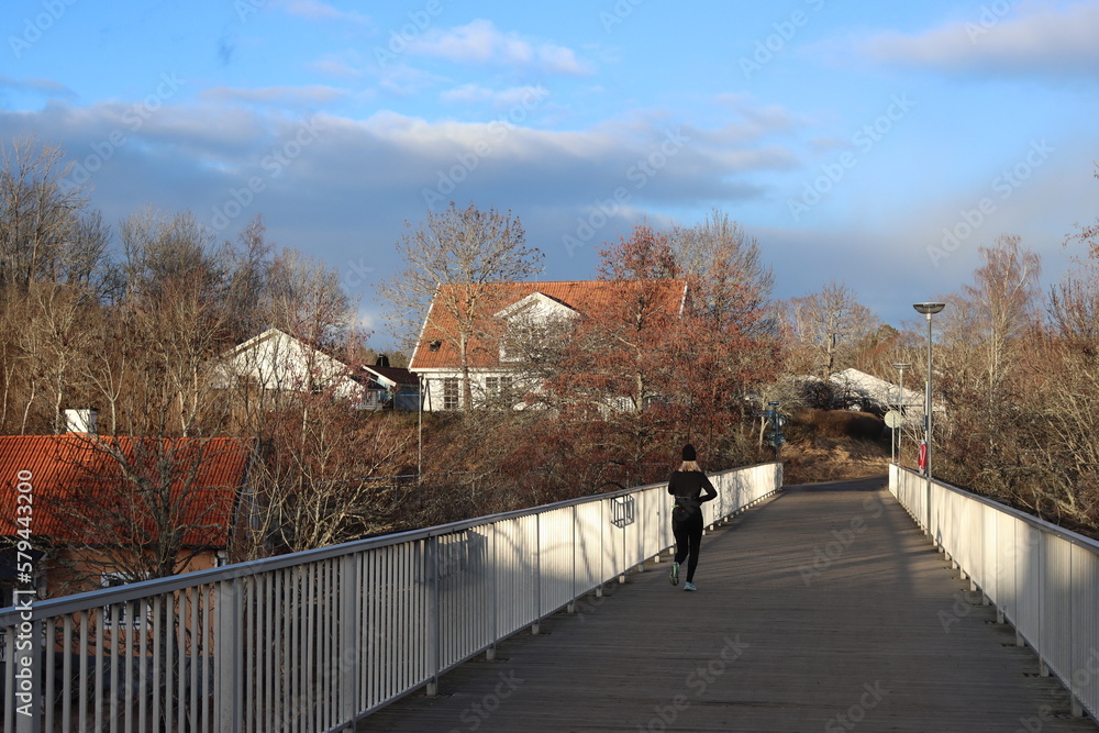 Sweden. Bridge for bicycles and pedestrians on which the athlete runs. Stangan-Kinda canal in Linköping. City of Linköping. Ostergotland province. Sweden. Bridge for bicycles and pedestrians on which the athlete runs. Stangan-Kinda canal in Linköping. City of Linköping. Ostergotland province.