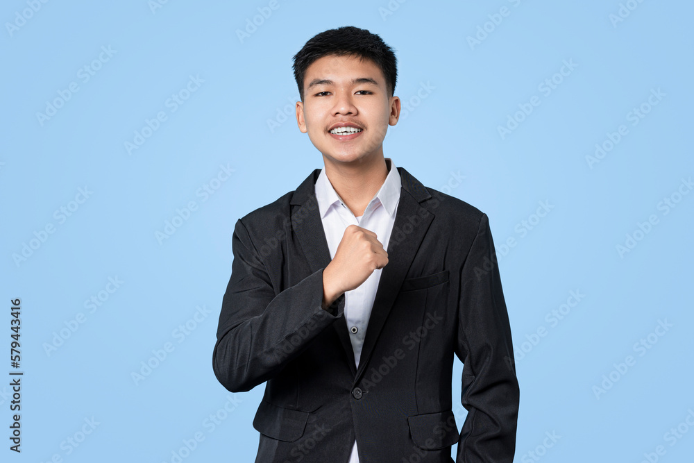 Young handsome asian businessman excited celebrating success isolated on blue light background Young handsome asian businessman excited celebrating success isolated on blue light background