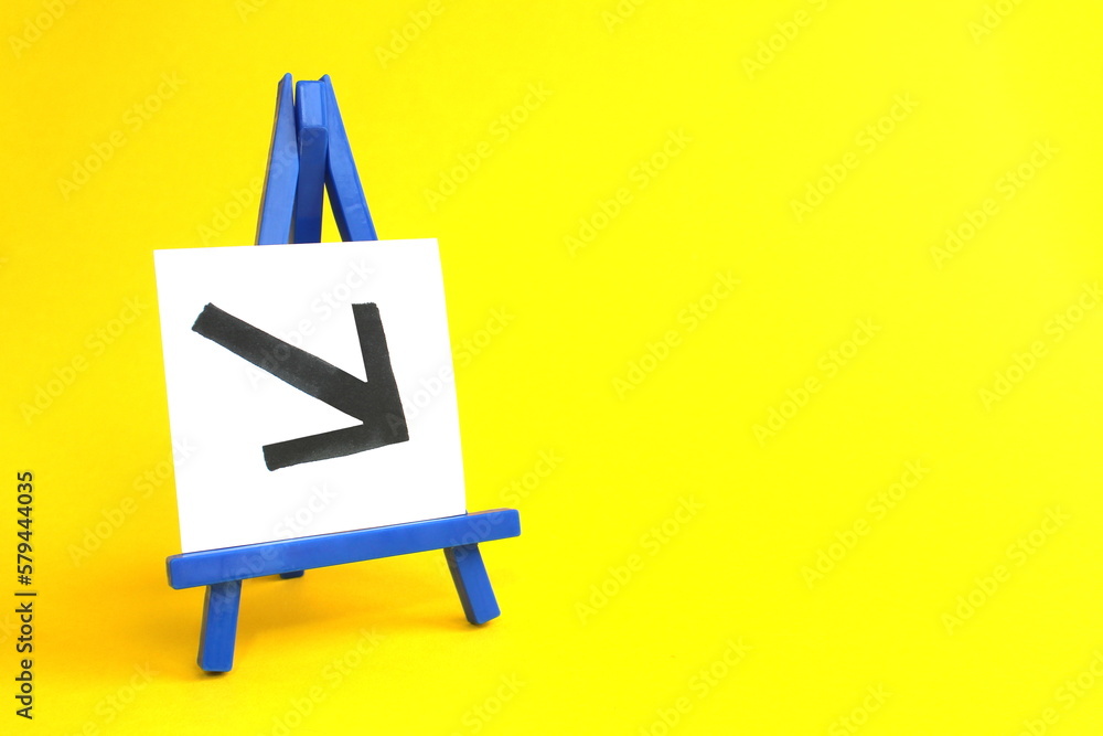 On a yellow background stands a miniature easel with a sheet of paper and a graph drawn on it. On a yellow background stands a miniature easel with a sheet of paper and a graph drawn on it.