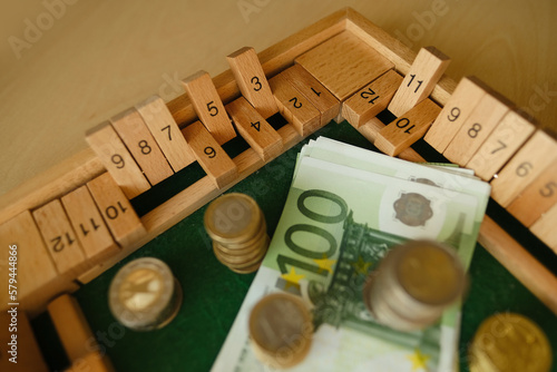 close up metal euro currency coin, banknotes of european union on wooden board game Philos Shut Box, concept gambling for money, financial growth, national currency, financial devaluation, inflation photo