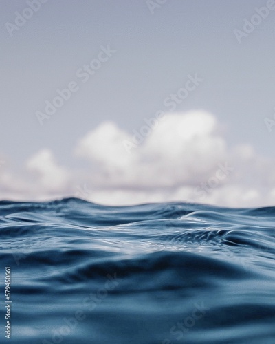 Vertical closeup shot from within an ocean in Western Australia, with clouds in the background