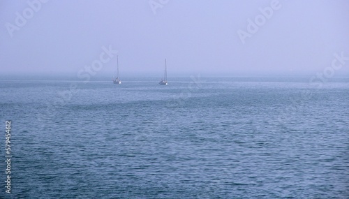 Sailboats in the foggy horizon of the sea