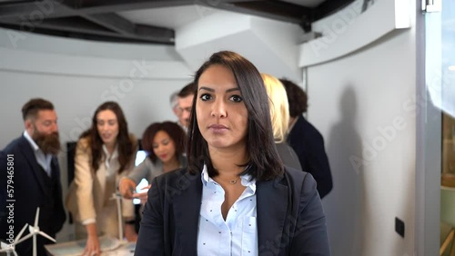 Young moroccan businesswoman working inside modern office with the multiethnic team behind her - Concept of leadership and teamwork achieving goals - Focus on eyes