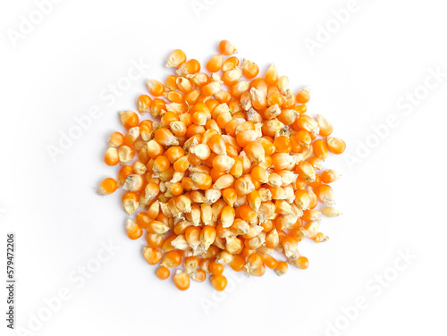 Raw dry orange colour popcorn grains,seeds isolated on white background.Pile of Raw uncooked dry corns.Popcorn kernels.