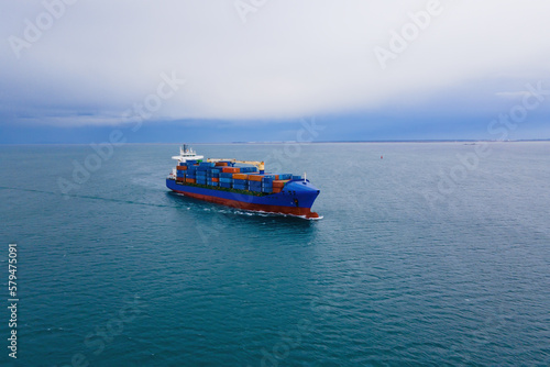 Aerial top view of cargo ship carrying container for export goods from cargo yard port to custom ocean concept freight shipping by ship