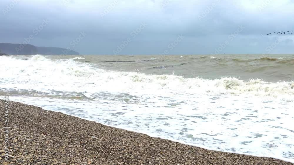 Powerful sea waves are crashing on the Black Sea coast. Waves splash on the beach with pebbles during a storm. Storm at sea. Panoramic view of the Black Sea. Russia. Sunset on the beach. 4K Powerful sea waves are crashing on the Black Sea coast. Waves splash on the beach with pebbles during a storm. Storm at sea. Panoramic view of the Black Sea. Russia. Sunset on the beach. 4K