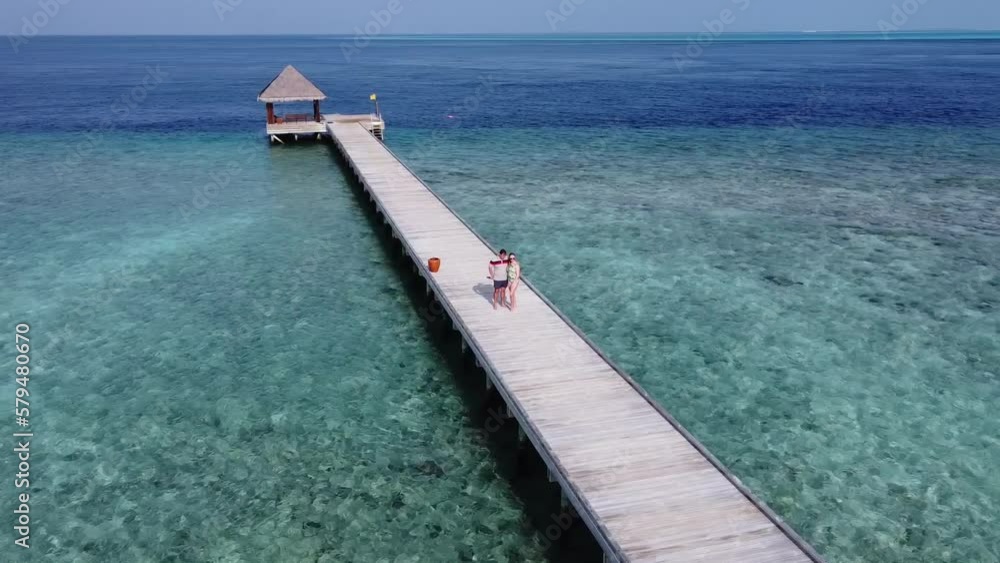 A man and a woman couple walking on wooden decking bridge holding hands A man and a woman couple walking on wooden decking bridge holding hands