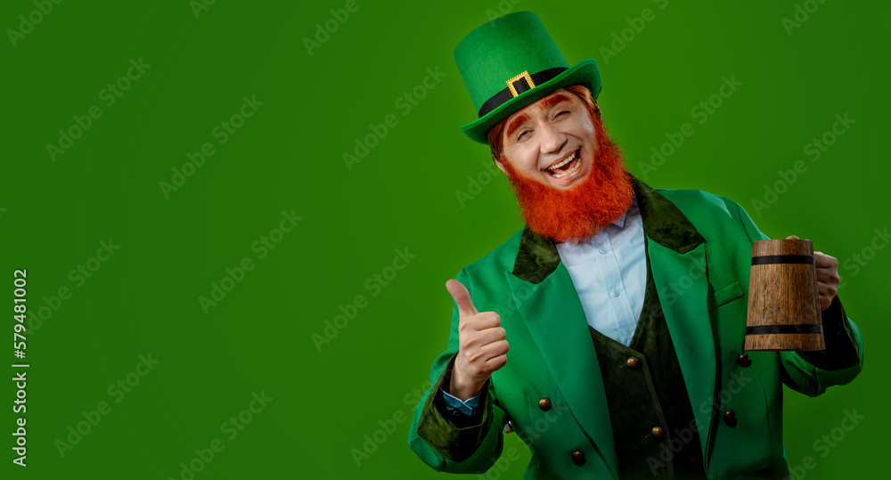 Leprechaun elf on St. Patrick's Day. Cheerful character Irish leprechaun for advertising with a red natural beard in a green suit and green hat for advertising. Cosplay at the festival on March 17th Leprechaun elf on St. Patrick's Day. Cheerful character Irish leprechaun for advertising with a red natural beard in a green suit and green hat for advertising. Cosplay at the festival on March 17th
