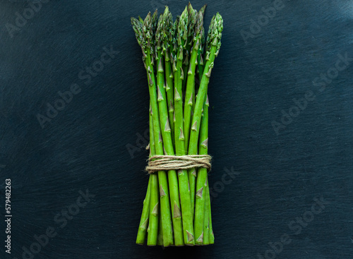 arrangement of vegetables, asparagus on a black background, top view, ingredients for cooking izhi, vegetarian dishes, recipes, healthy food, diet, health