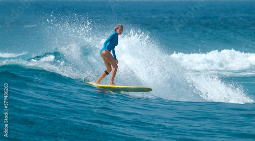 Photography Young woman surfer rides the wave in the Maldives
