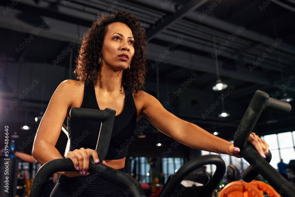 african american woman cardio slimming aerobics training on bicycle
