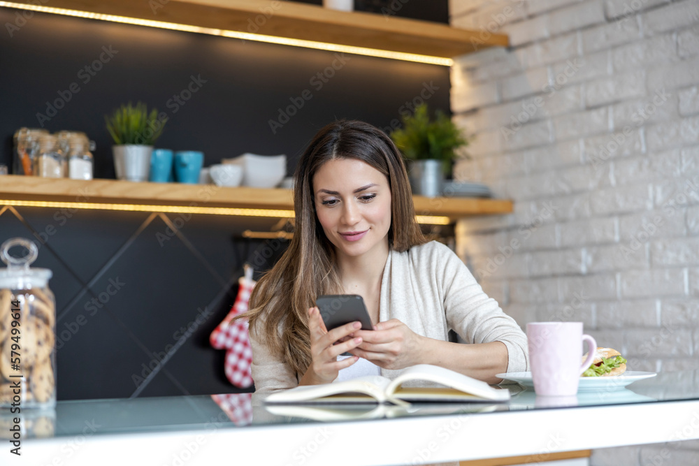 Smiling woman using smartphone at home Smiling woman using smartphone at home