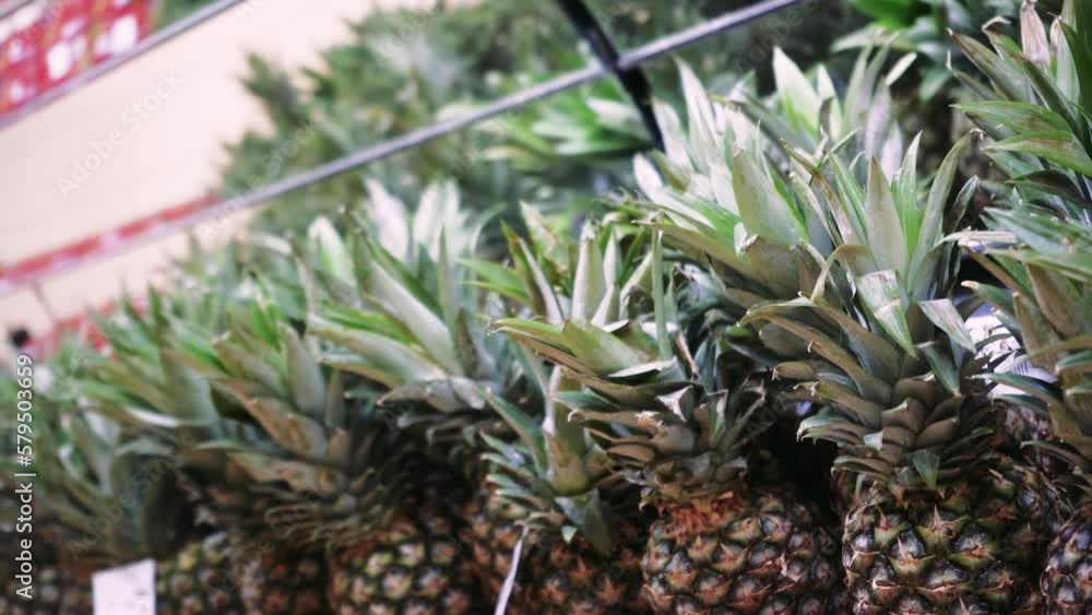 Frames of containers with ripe pineapple fruits in the food passage in the supermarket. Natural fruits for a healthy diet. The concept of a healthy diet. Frames of containers with ripe pineapple fruits in the food passage in the supermarket. Natural fruits for a healthy diet. The concept of a healthy diet.