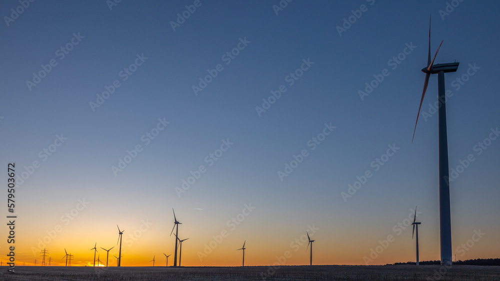 Windkrafträder auf einem Feld bei Sonnenaufgang