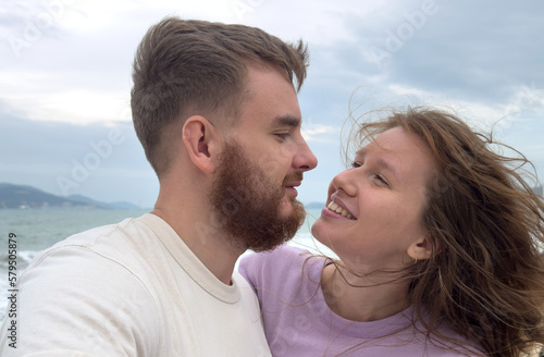 Happy couple in love is enjoy summer vacation on sea, beach take selfie photo, picture of themself on phone, smartphone, hug each other  © Евгений Шемякин
