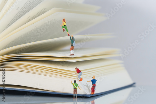 climbers, mountaineers climb a book in teamwork