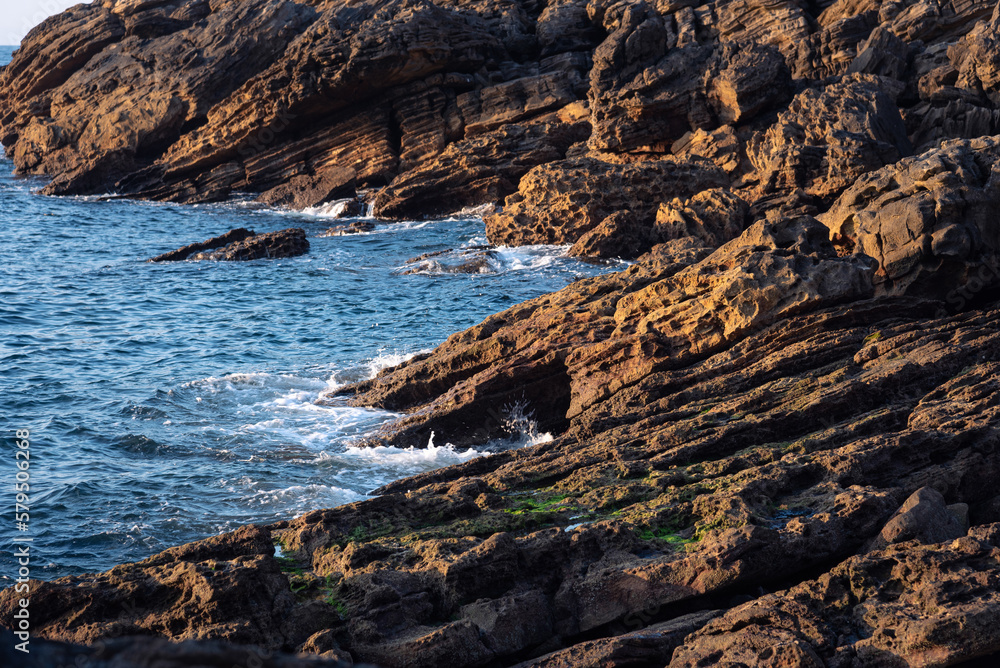 Beautiful rock formations in the natural coast of Hondarribia with small waves coming to the shore, Hondarribia, Guipuzcoa, Basque Country, Spain