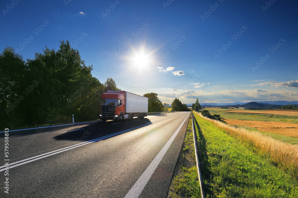 Obraz premium Truck transport on the road at sunset and cargo 