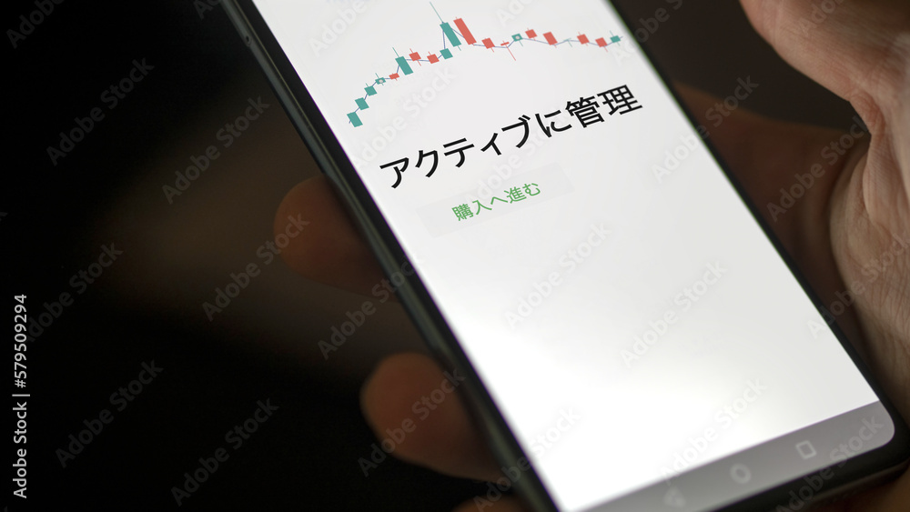An investor analysing an ETF on a screen. Funds stocks exchange with Japanese text: Actively manage, buy An investor analysing an ETF on a screen. Funds stocks exchange with Japanese text: Actively manage, buy